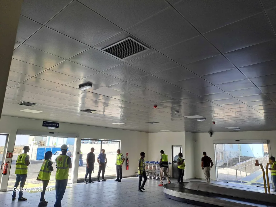 Interior do terminal — tetos metálicos e recolha de bagagem