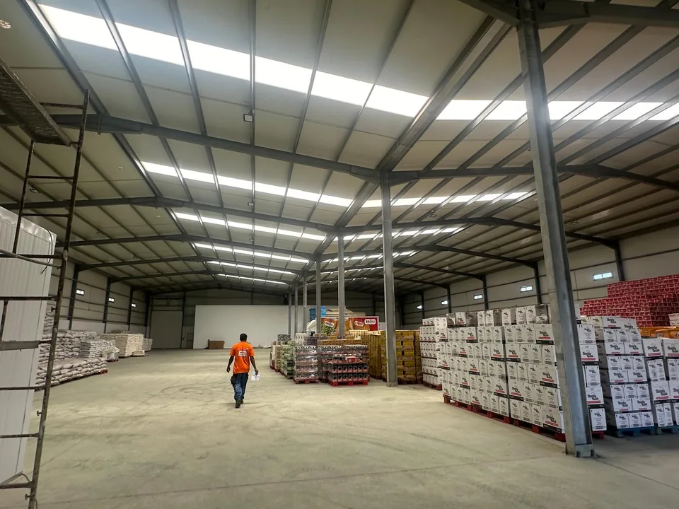 Interior do pavilhão Importex em funcionamento — armazém com mercadoria