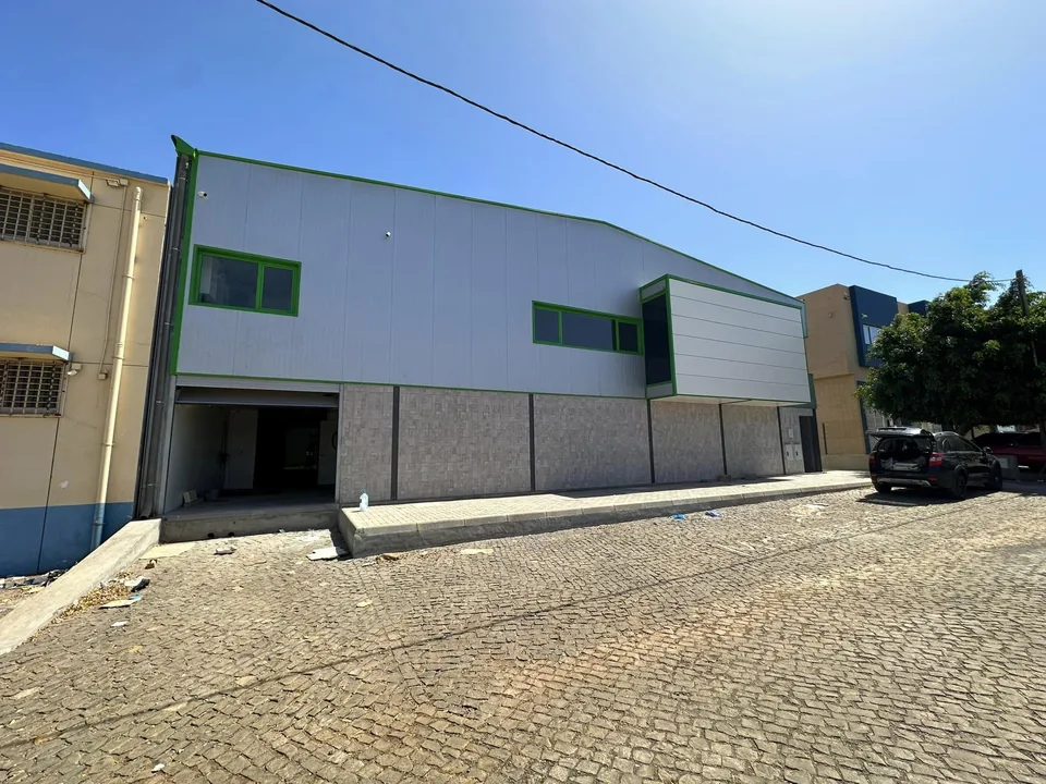 Fachada lateral do pavilhão Morabeza Fresh em painel sandwich com remates verdes